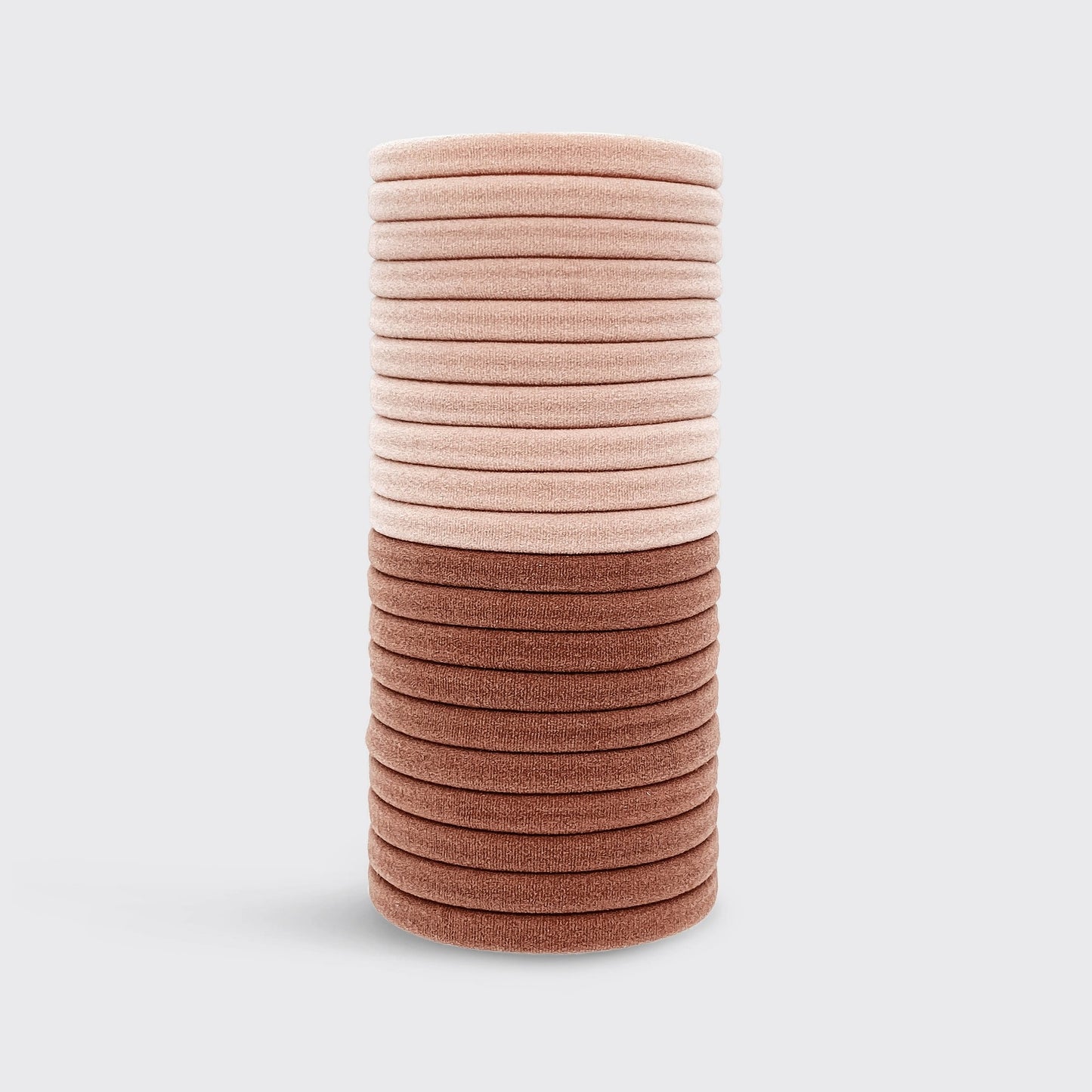 Stack of pink hair ties on a light gray background
