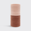 Stack of pink hair ties on a light gray background