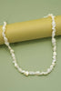 Pearl necklace on a green background