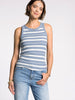 Woman wearing a blue and white striped tank top and light blue jeans on a white background
