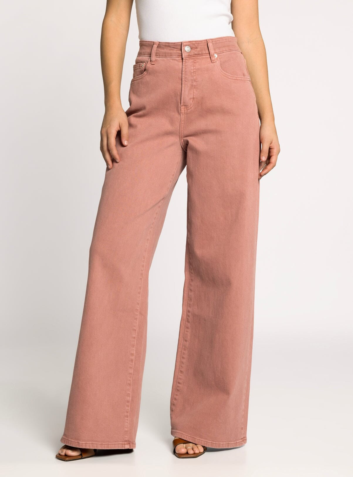 Person wearing pink wide-leg jeans on a white background