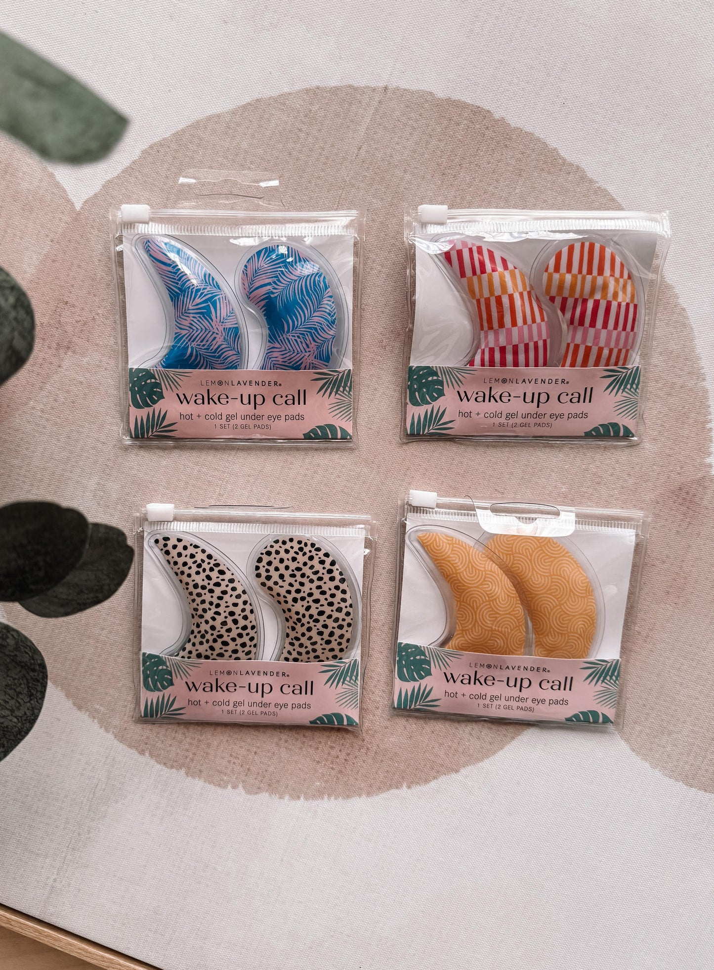 Four pairs of wake-up call eye masks in different designs on a textured surface.