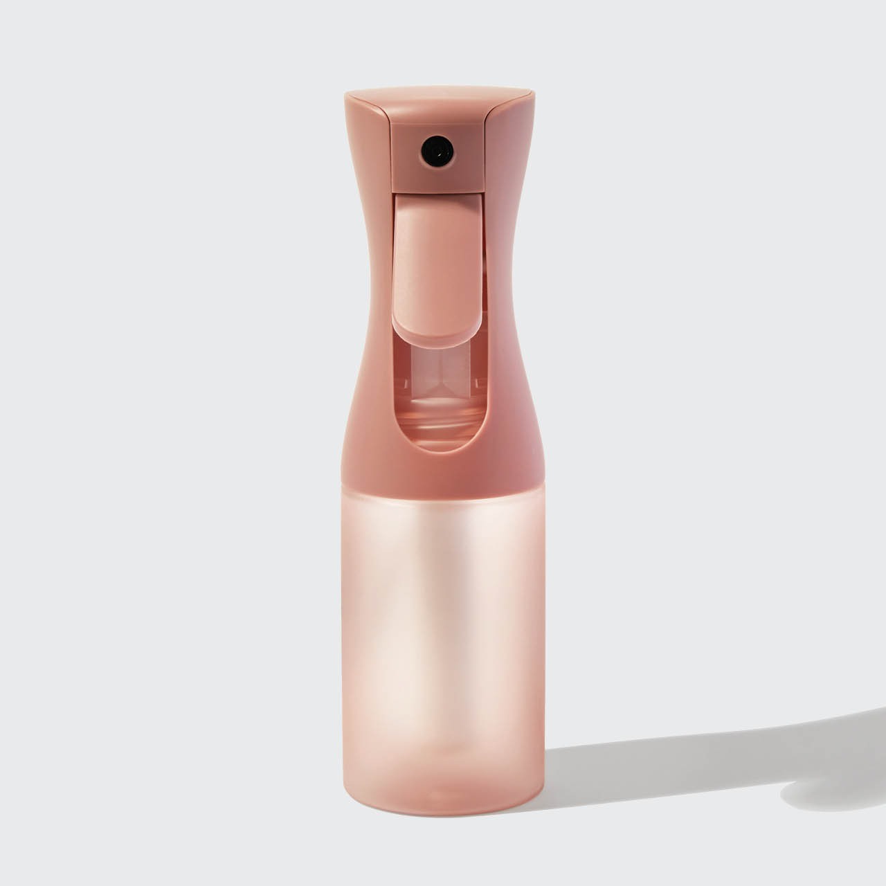 Pink spray bottle on a light gray background