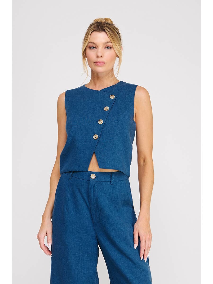 Woman wearing a blue sleeveless top with buttons and matching pants on a white background