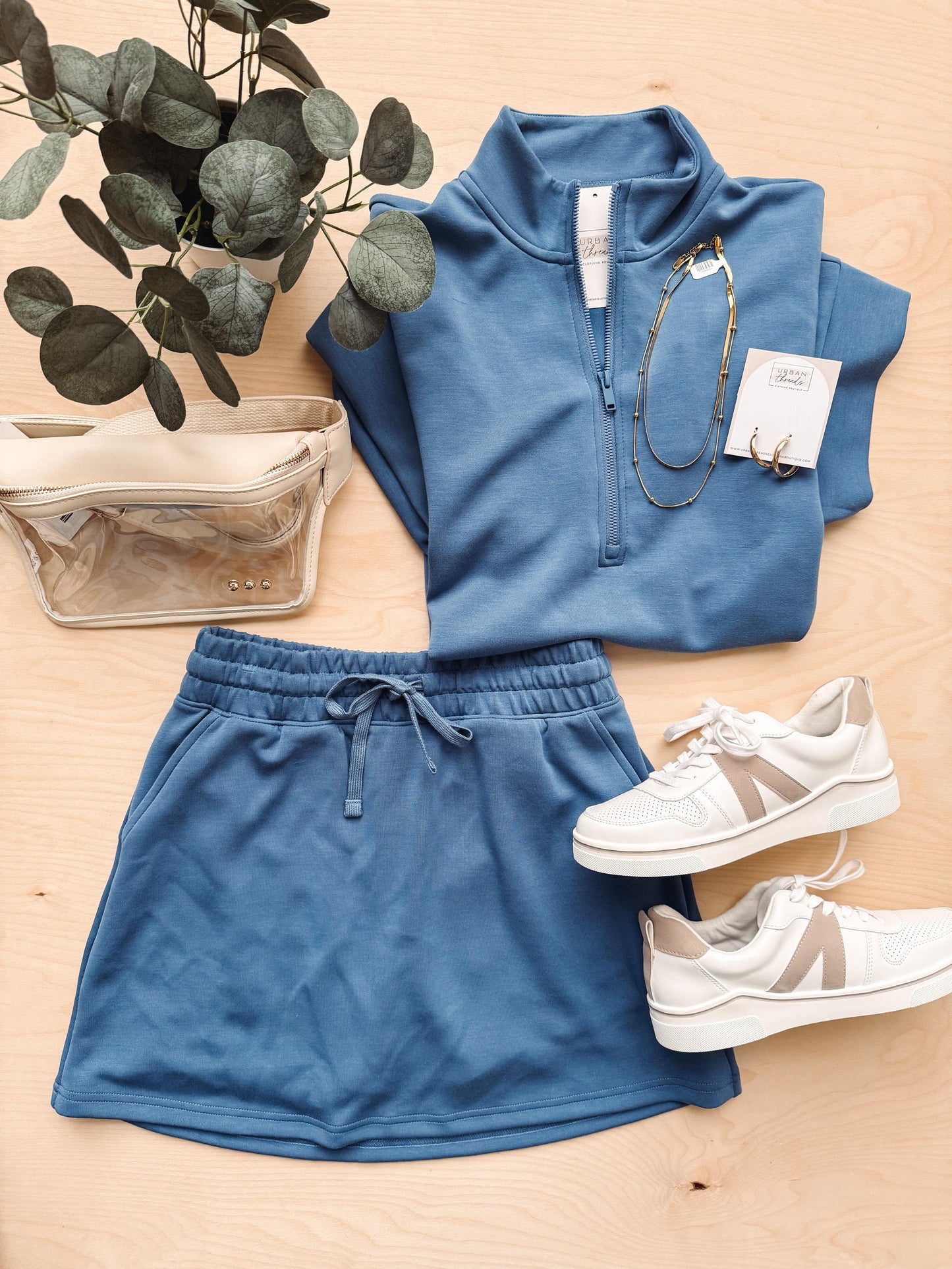 Blue tracksuit with white sneakers on a wooden surface