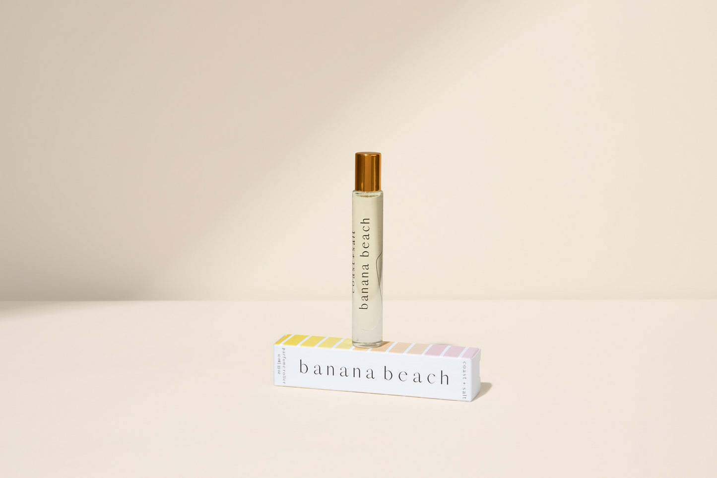 Banana Beach perfume bottle and packaging on a beige background
