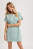Woman wearing a green and white striped dress on a plain background