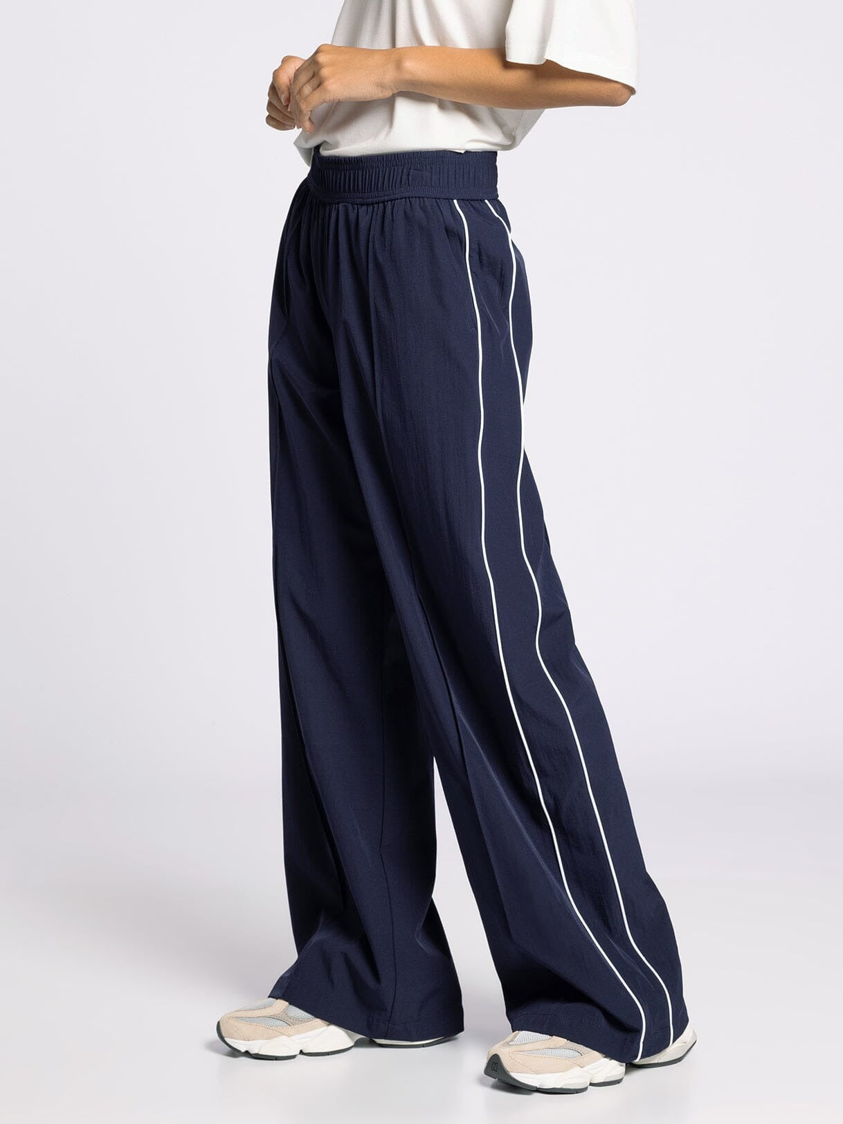 Navy wide-leg pants with a white stripe on a white background