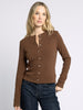 Woman wearing a brown cardigan with a plain background