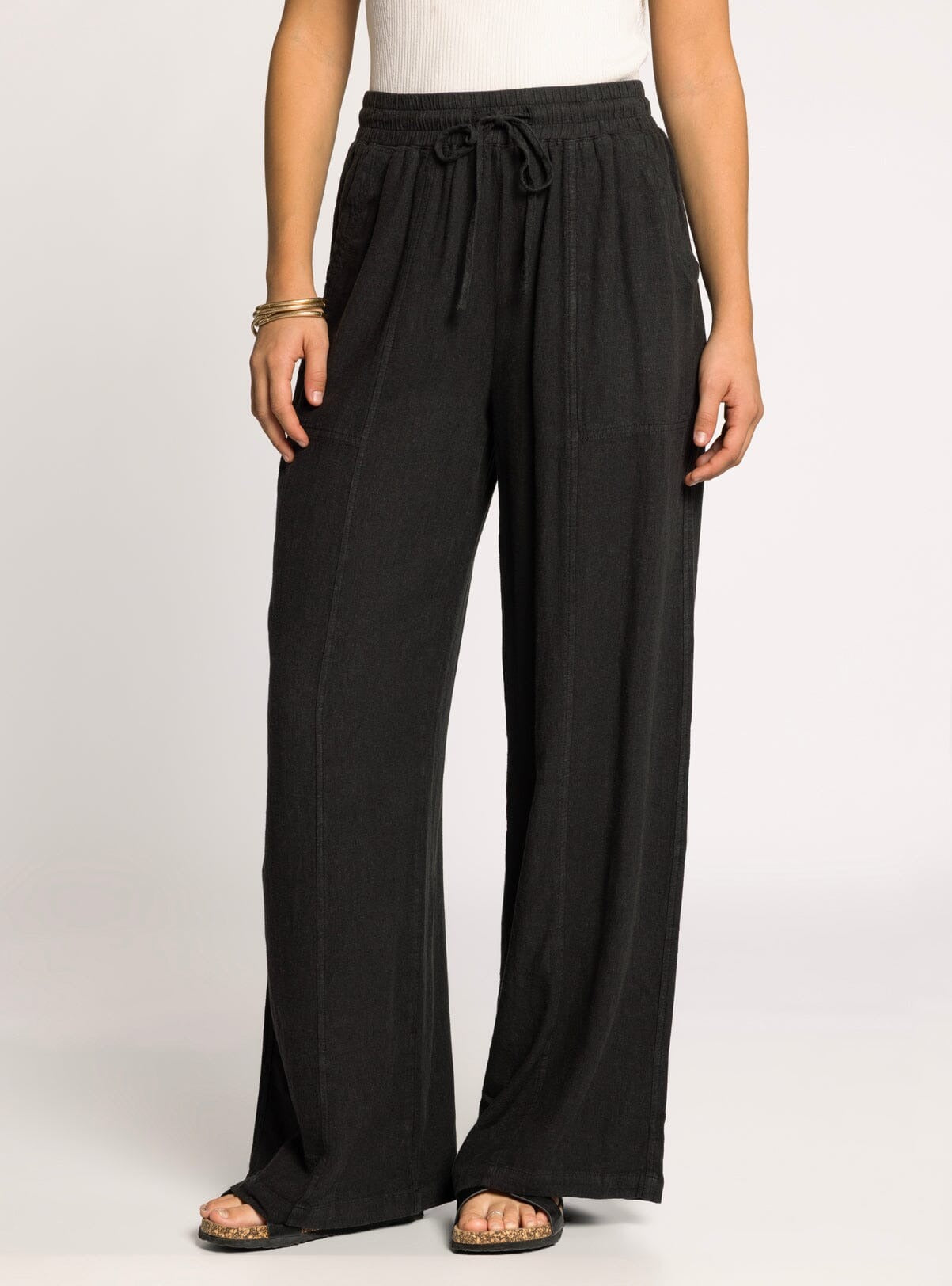 Black wide-leg pants worn by a person on a white background