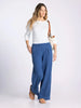 Woman wearing a white striped shirt and blue pants on a white background