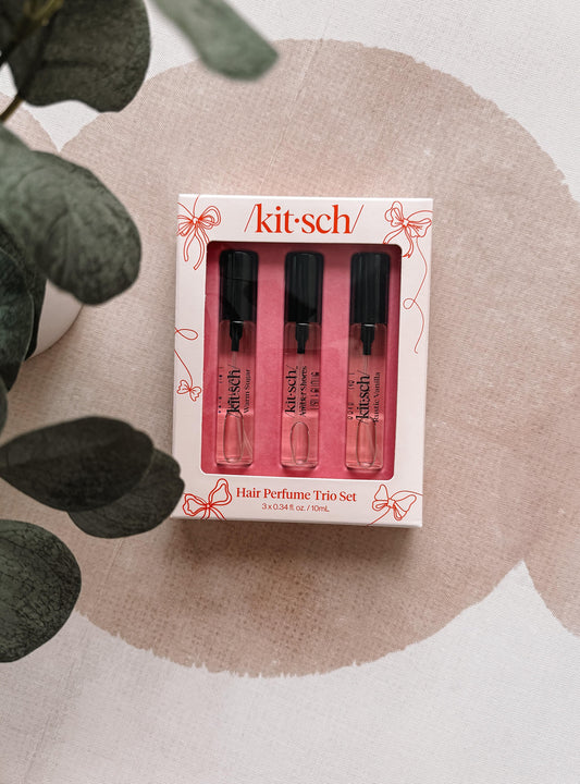 kitsch hair perfume trip set packaging on a neutral background with leaves.