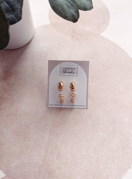 Pair of gold earrings on a 'Urban Threads' branded card against a neutral background