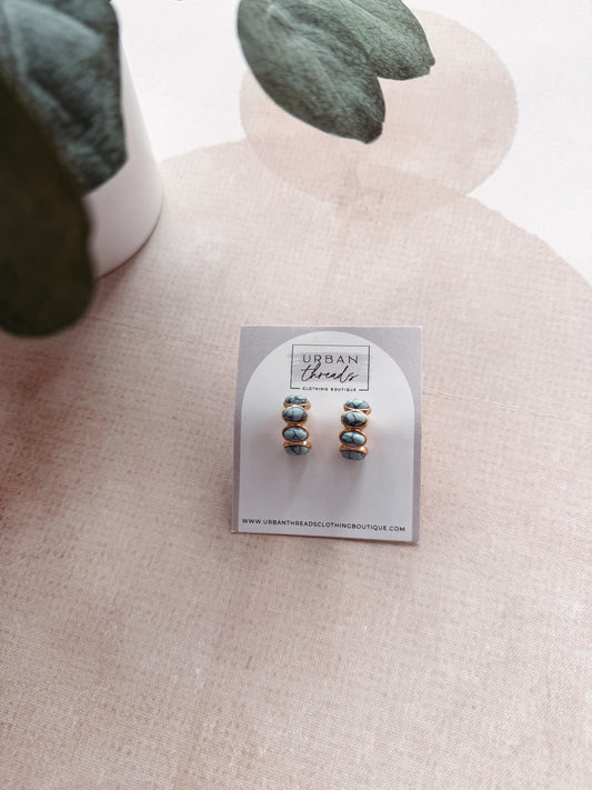 Pair of earrings on a card with 'Urban Threads' branding, displayed on a neutral background.