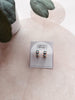 Pair of earrings on a card with 'Urban Threads' branding, displayed on a neutral background.
