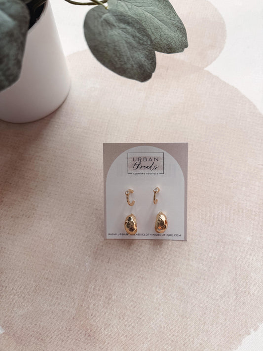 Pair of gold hoop earrings on a branded card with a soft background