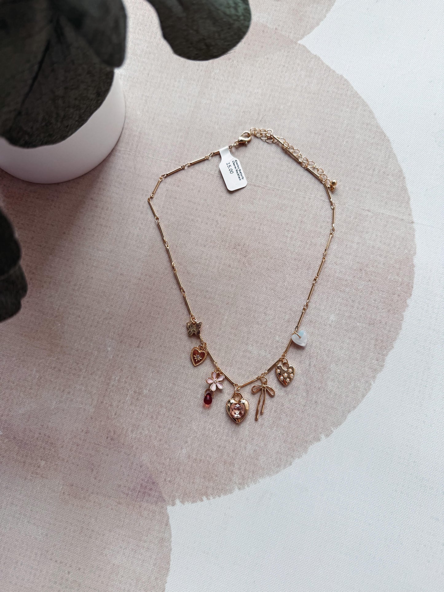 Necklace with charms on a pink fabric background
