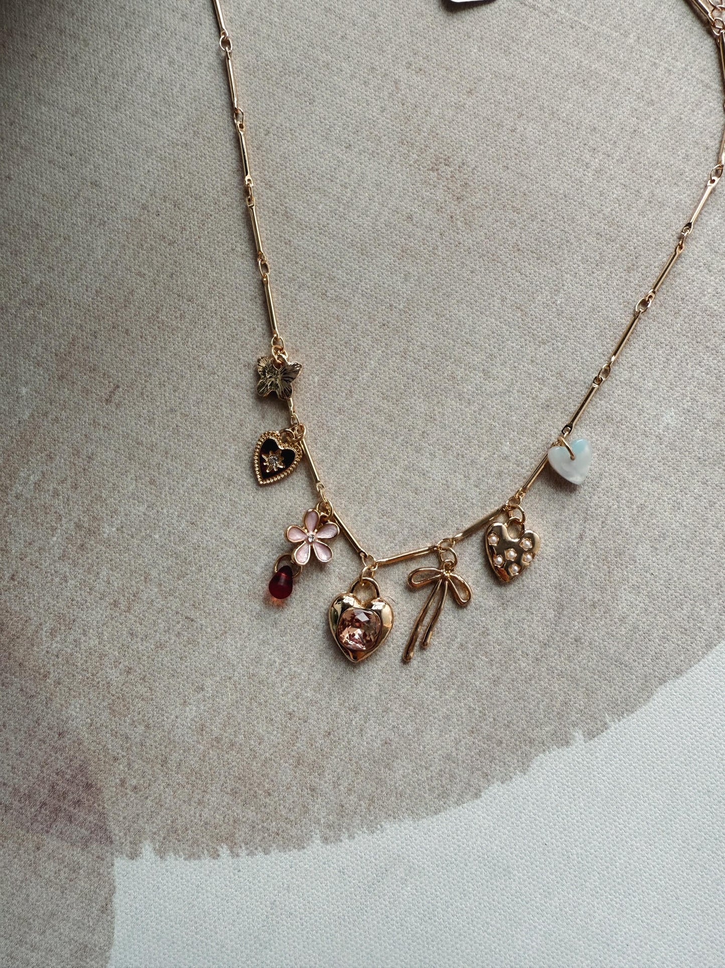Necklace with various charms on a textured surface
