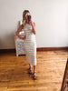 Woman taking a mirror selfie wearing a striped dress in a room with wooden flooring.