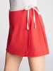 Red apron with a white tie on a plain background