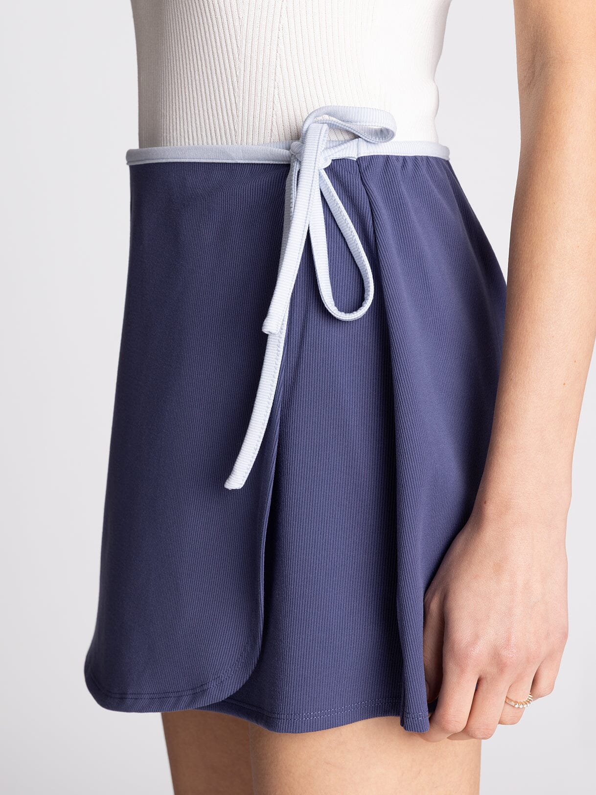 Navy blue shorts with a white drawstring on a light gray background